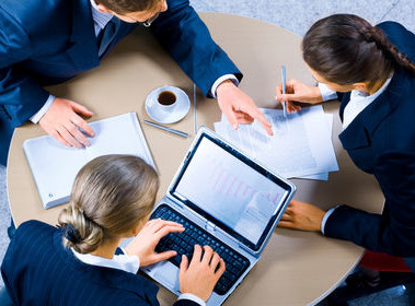 Image of three business people working at meeting